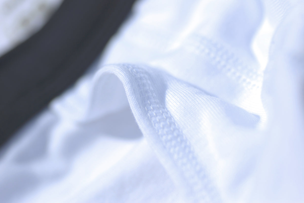 Gros plan sur le tissu en côte fine du slip taille haute ouvert blanc.