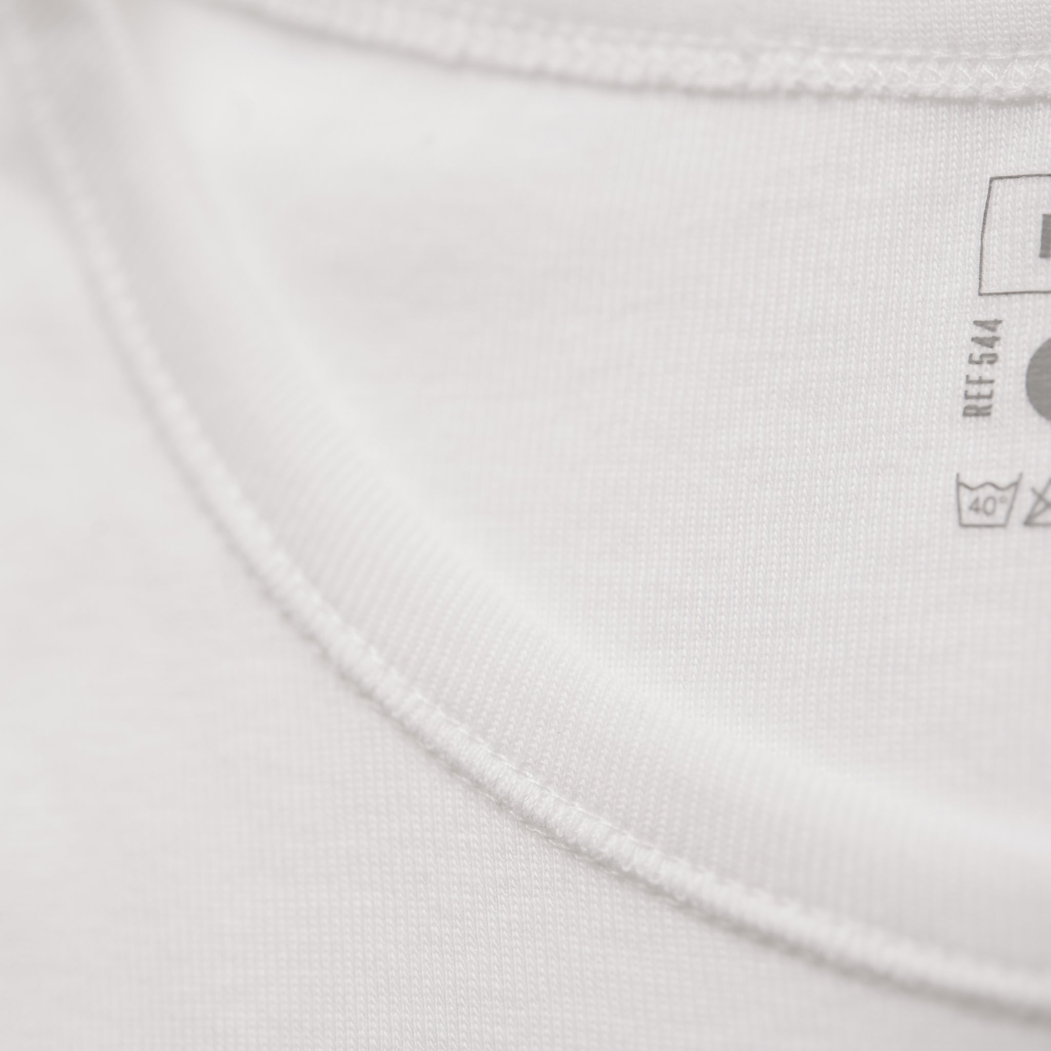 Détail du col rond du T-shirt blanc, finition en coton fin de haute qualité