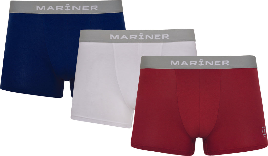 Lot de shortys en coton blanc, bleu marine et rouge, présenté à plat.